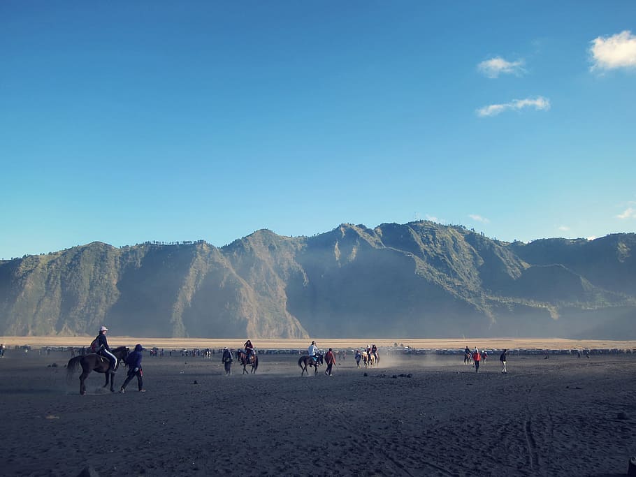 riding people on horses during daytime, group of people roaming in front of a moutain HD wallpaper