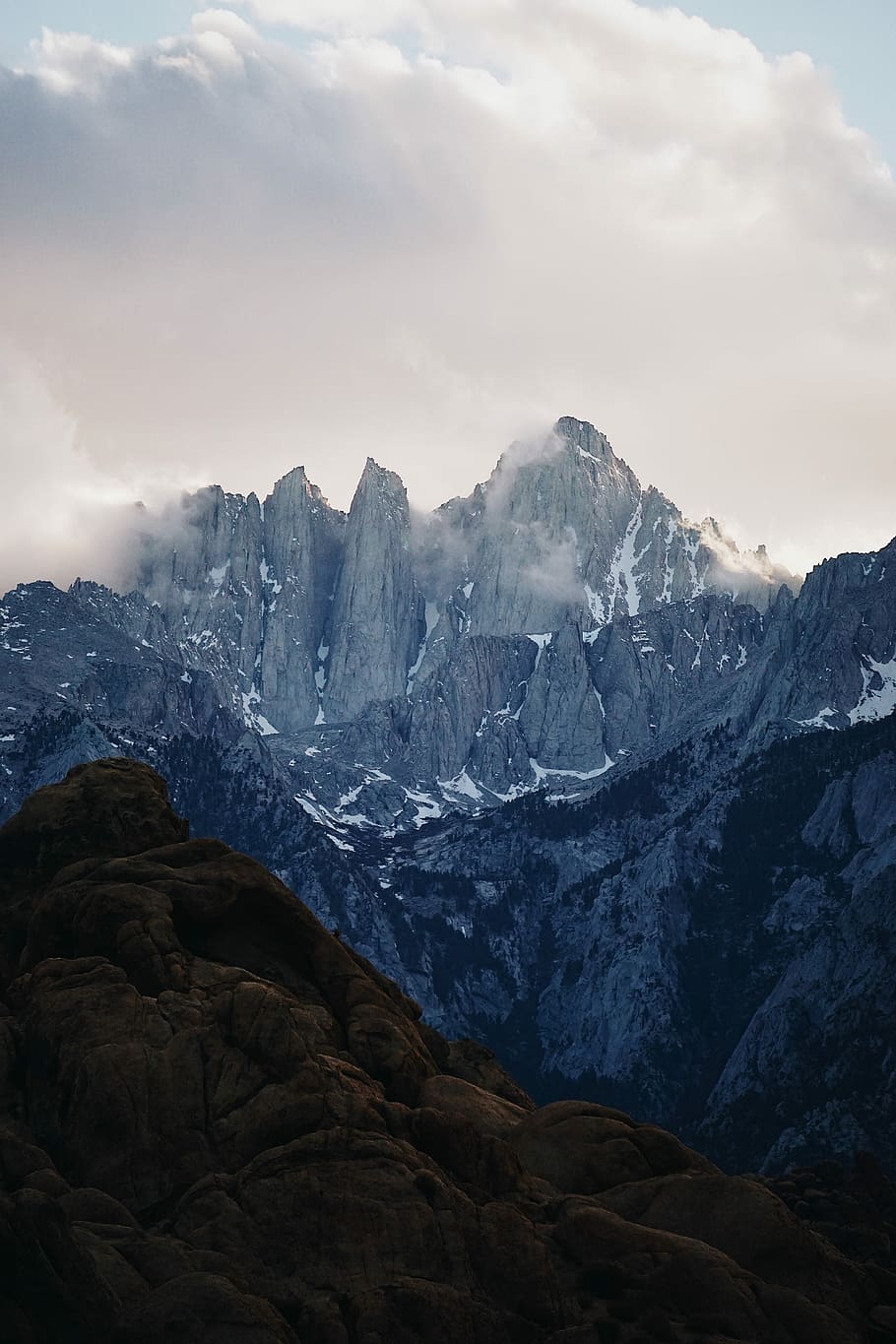 photo of gray mountains under cloudy sky, mountain peak during daytime