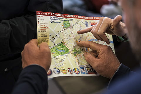 two people pointing at London's number one sightseeing map, person holding London map HD wallpaper