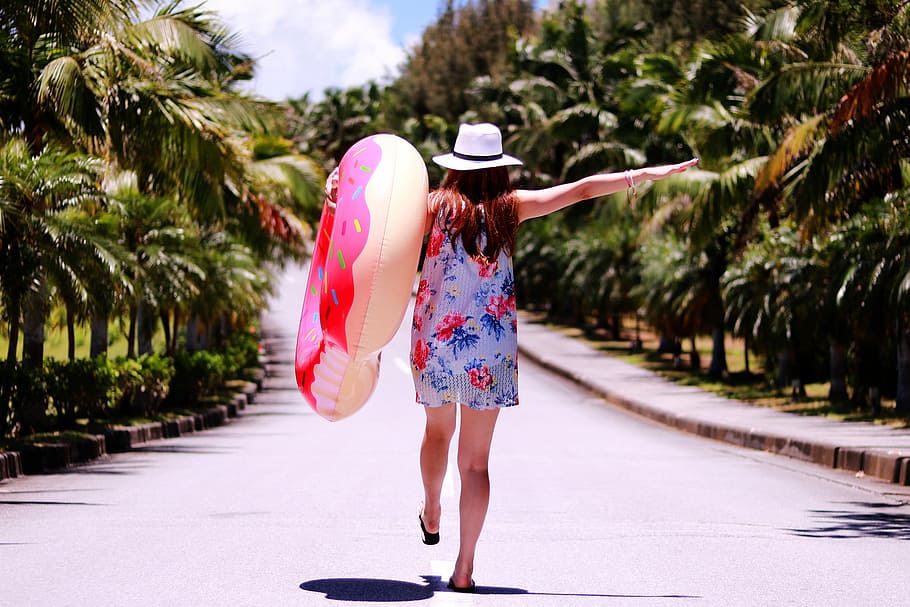 woman in blue and pink sleeveless dress holding buoy during daytime HD wallpaper