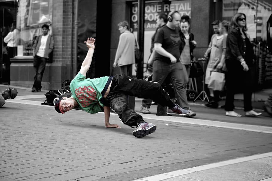 selective color photo of man in green and red t-shirt, b-boying