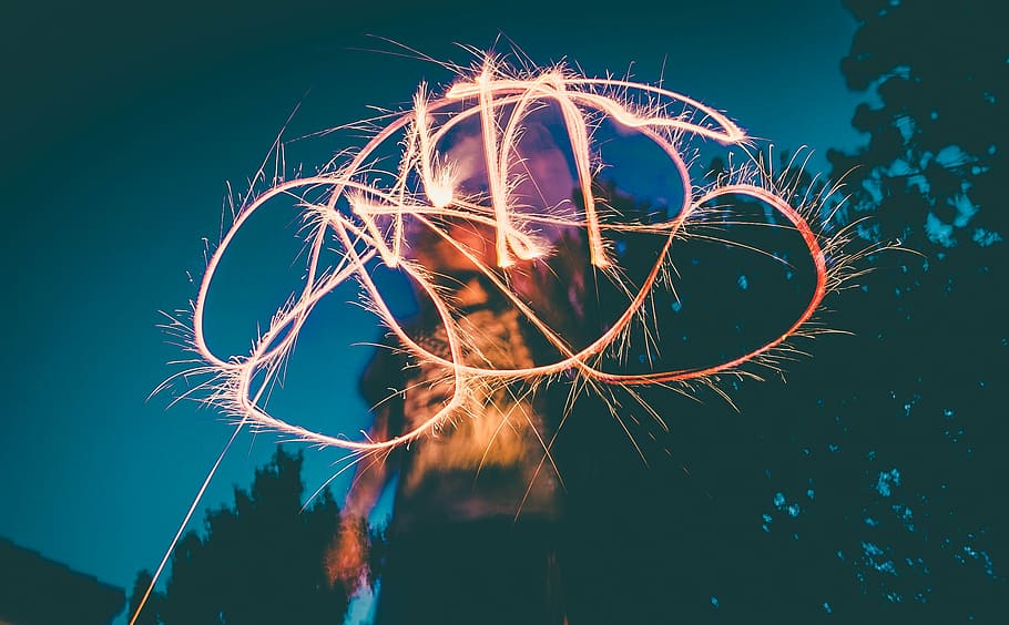 time-lapse photography of person holding sparkler, selective HD wallpaper