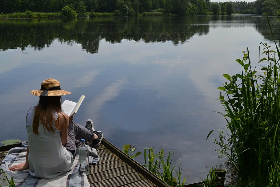 woman in gray sleeveless top reading book beside sitting on dock during daytime HD wallpaper