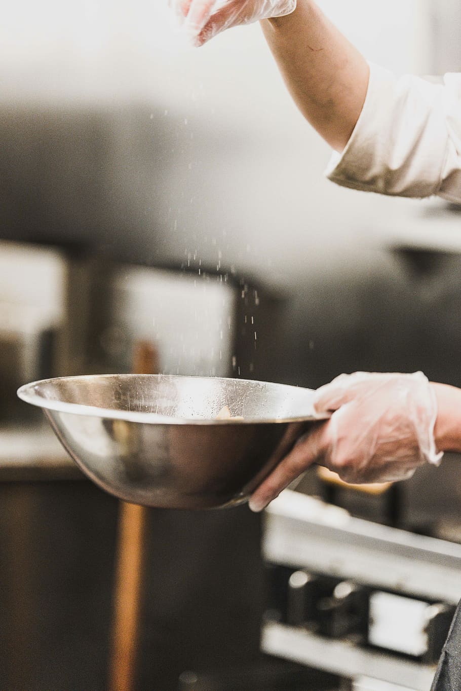 person garnishing on gray stainless steel bowl, white powder sprinkle on stainless steel bowl HD wallpaper