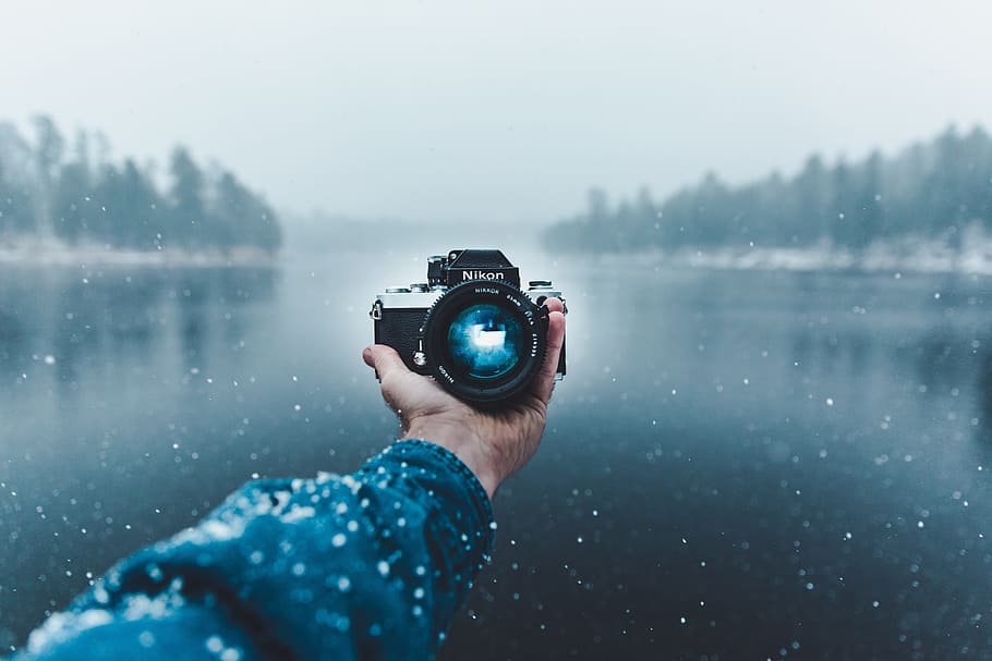 selective focus photography of Nikon camera on person's hand HD wallpaper