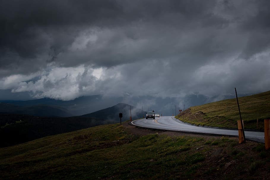 black car on gray asphalt road under cloudy sky, car on asphalt road distance with mountains during daytime HD wallpaper