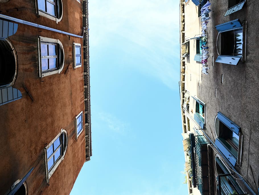 low-angle photography of two concrete establishments, brown and gray buildings under sunny sky HD wallpaper