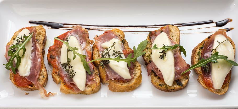 cooked food on white ceramic plate, bruschetta, starters, cheese