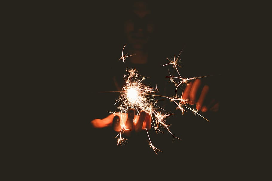 person holding sparkler, lighted sparkler, firework, hand, night HD wallpaper
