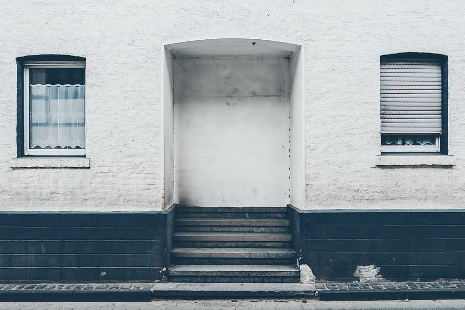 close up photo of white and black concrete building's entrance, white wooden windowpane