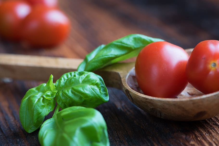 tomatoes and green leaves on top of brown wooden table, small tomatoes HD wallpaper