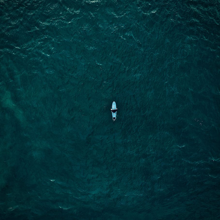 aerial view of person riding kayak boat, person riding teal kayak in the middle of body of water