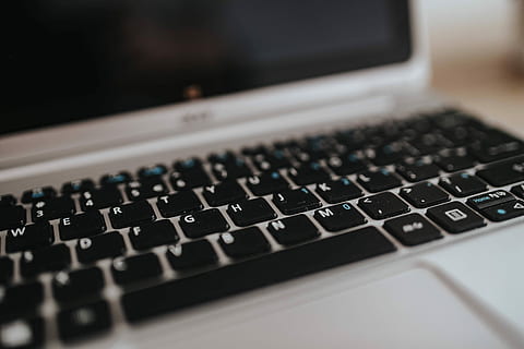 Silver Acer laptop on a wooden desk with a green plant, pencils and an Apple iPhone HD wallpaper