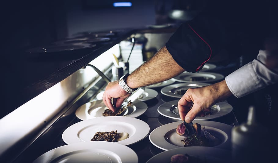 person preparing cooked dish, chef plating a dish, persons, dishes