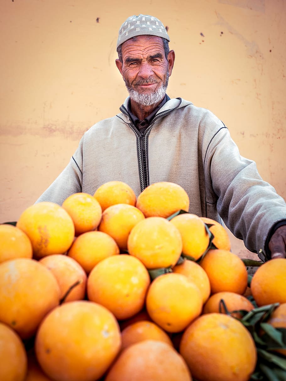 man holding oranges, man smiling near yellow citrus fruits, person HD wallpaper