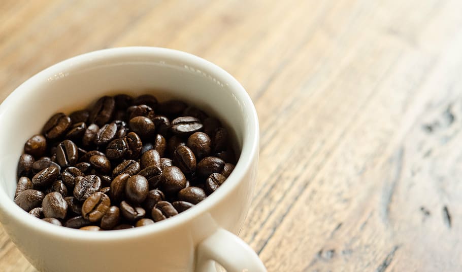 white ceramic coffee mug with coffee beans on top of brow wooden surface HD wallpaper