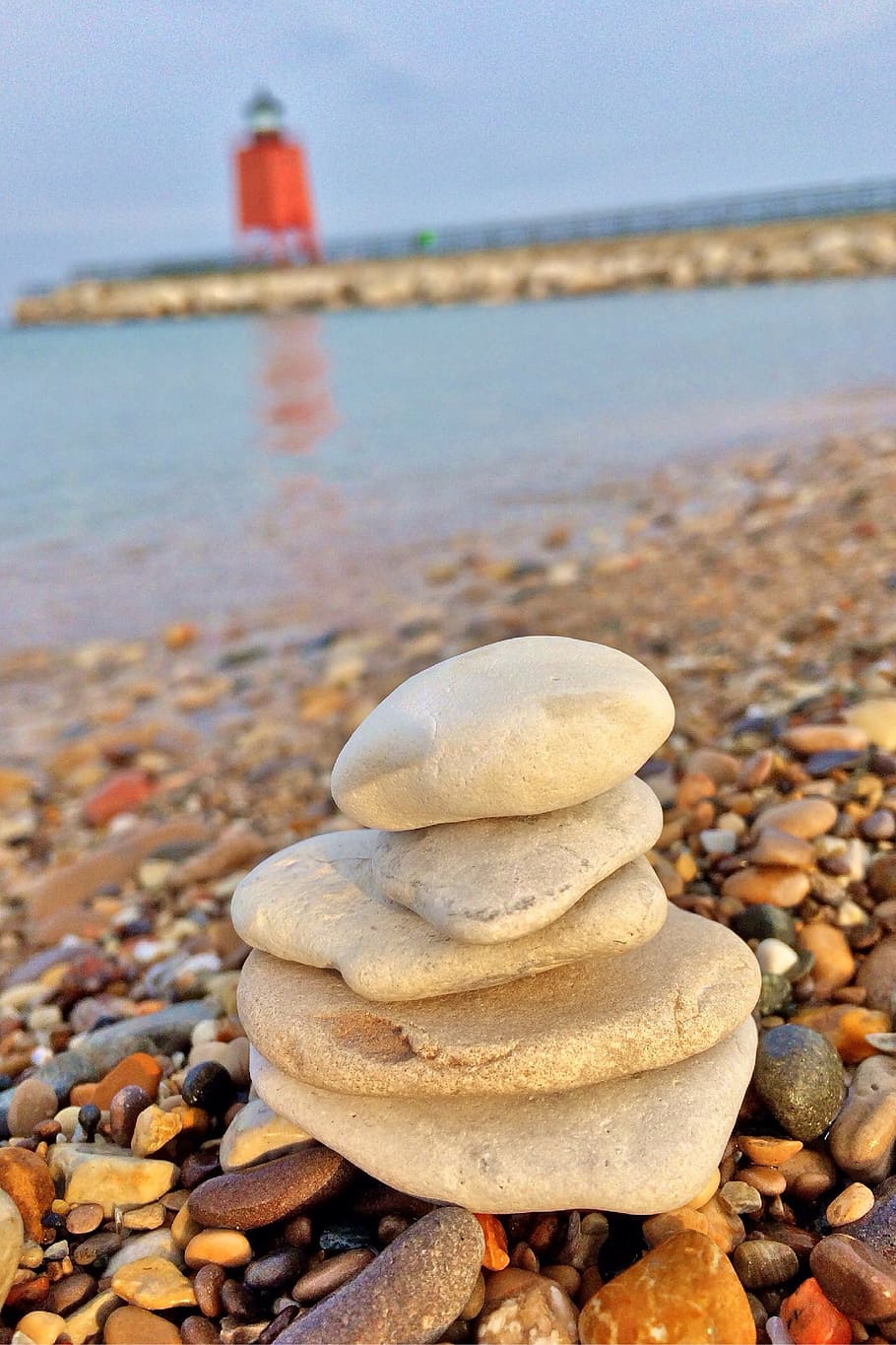 cairn near body of water, stacking stones, lighthouse, michigan
