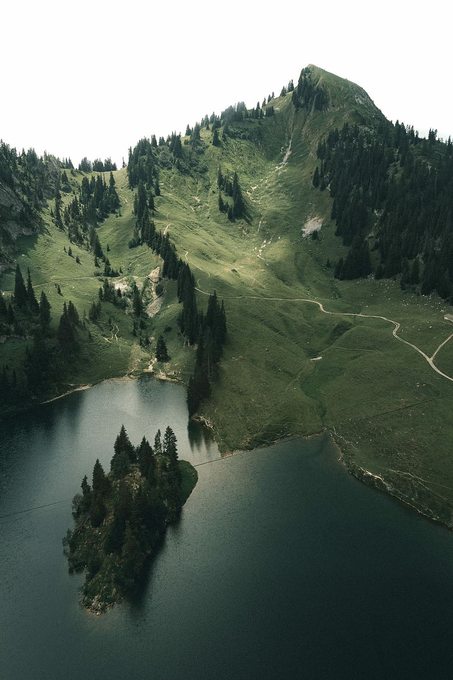 aerial photography of green mountains beside body of water under white sky HD wallpaper