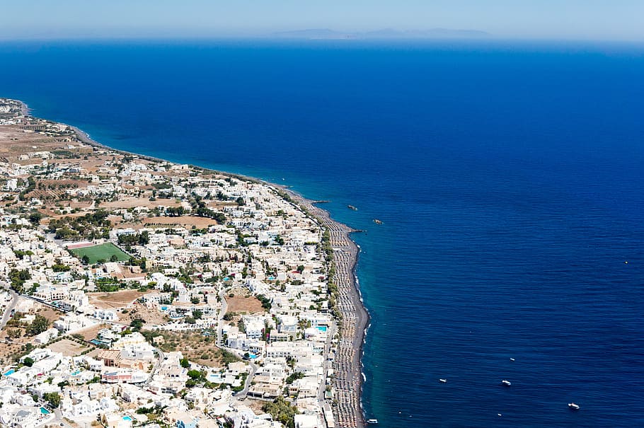 aerial photo of white and brown city beside blue calm body of water at daytime HD wallpaper