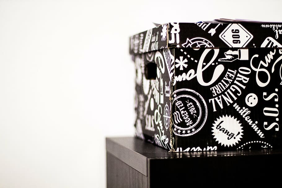 black and white printed box with lid on top of black table HD wallpaper