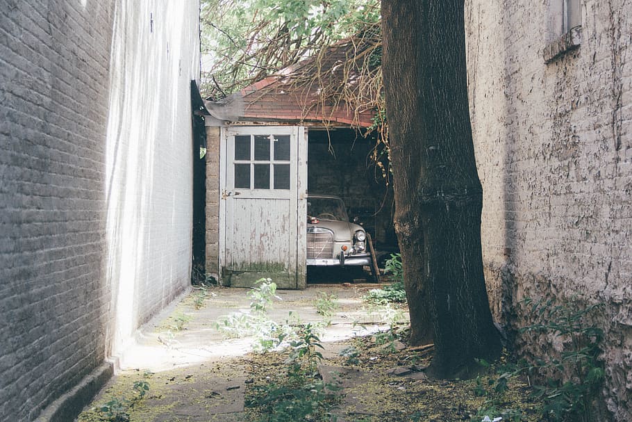 vintage white car inside of opened garage by the alley, broken HD wallpaper