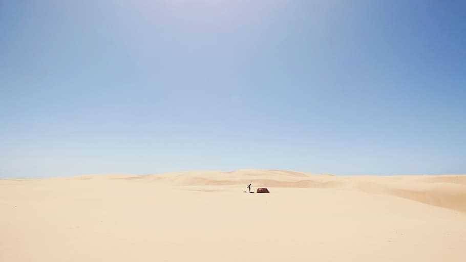 desert under blue sky, person in the middle of the desert during daytime HD wallpaper