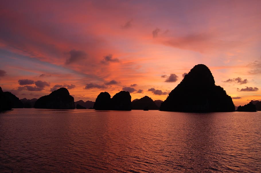 calm body of water near scattered large island, sunset, karst