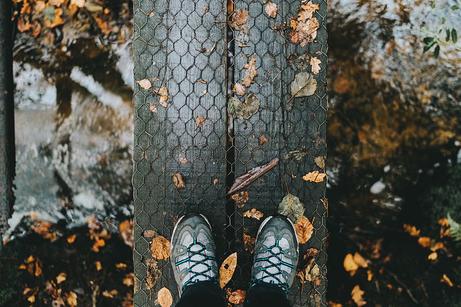 person showing pair of gray shoes, person standing on gray wooden planks HD wallpaper