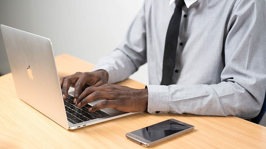 man sits typing on MacBook Air on table, man typing on MacBook Air HD wallpaper