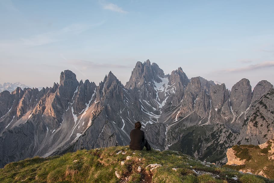 person sitting on top of the mountain watching mountain range HD wallpaper