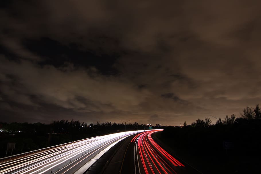 timelapse photography of passing cars on road at nighttime, time lapse photography of cars running on a highway during night time