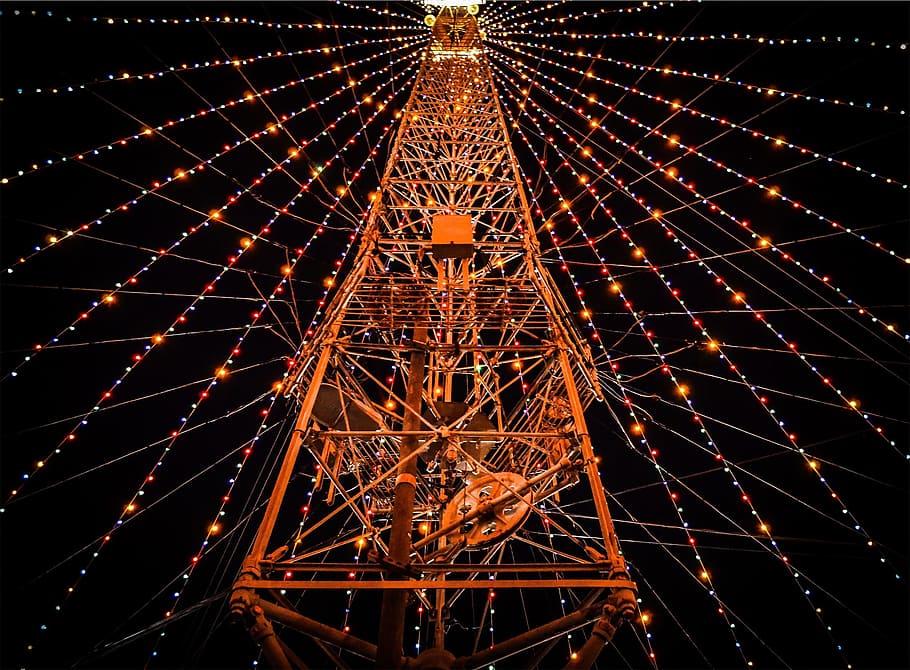 low-angle photography of red metal tower surrounded with turned on assorted-color string lights at night HD wallpaper