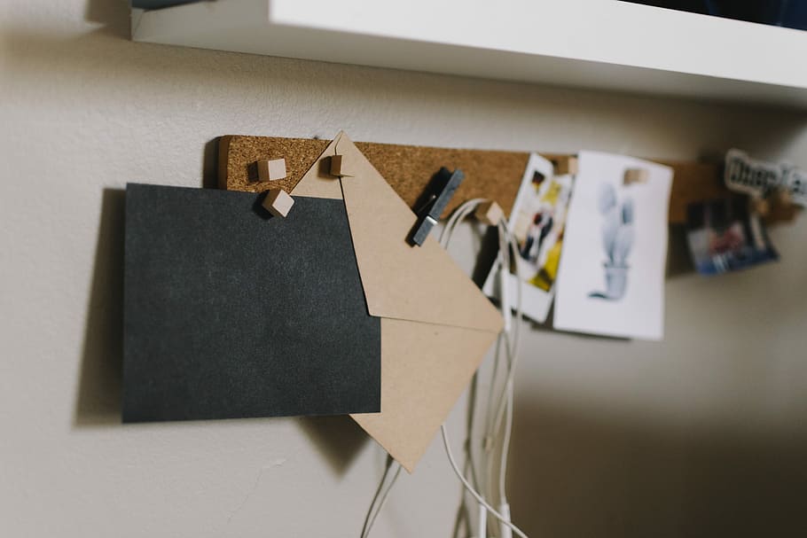 brown cork board with papers, two black and beige paper envelopes in pin organizer HD wallpaper