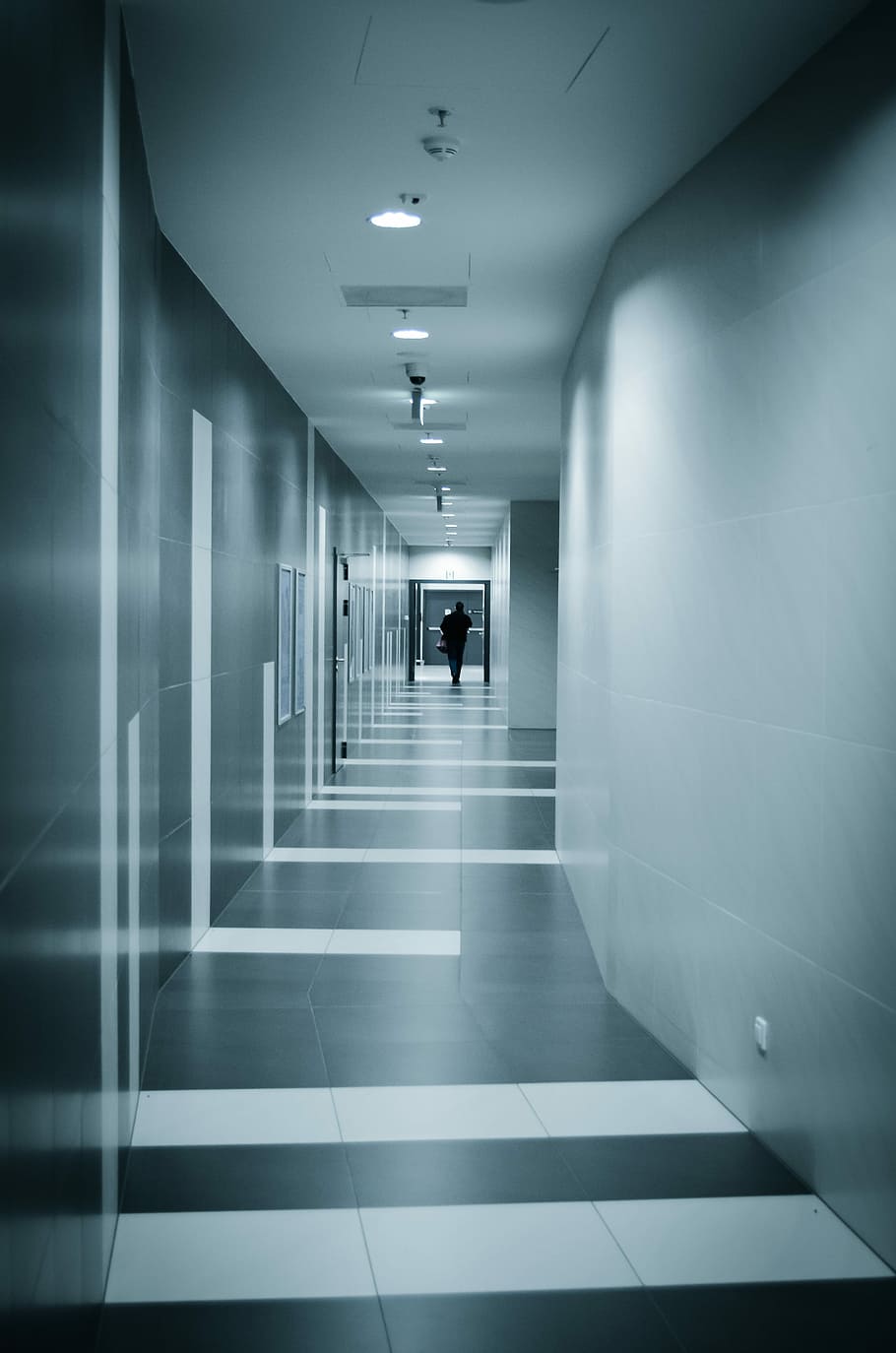 close photo of person walking in pathway on building, corridor