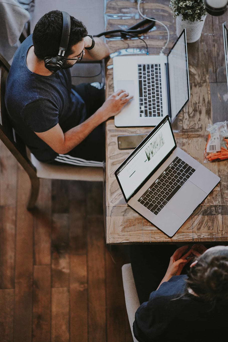 man sitting on chair and looking laptop computer, man sitting on brown wooden chair touching MacBook Pro HD wallpaper