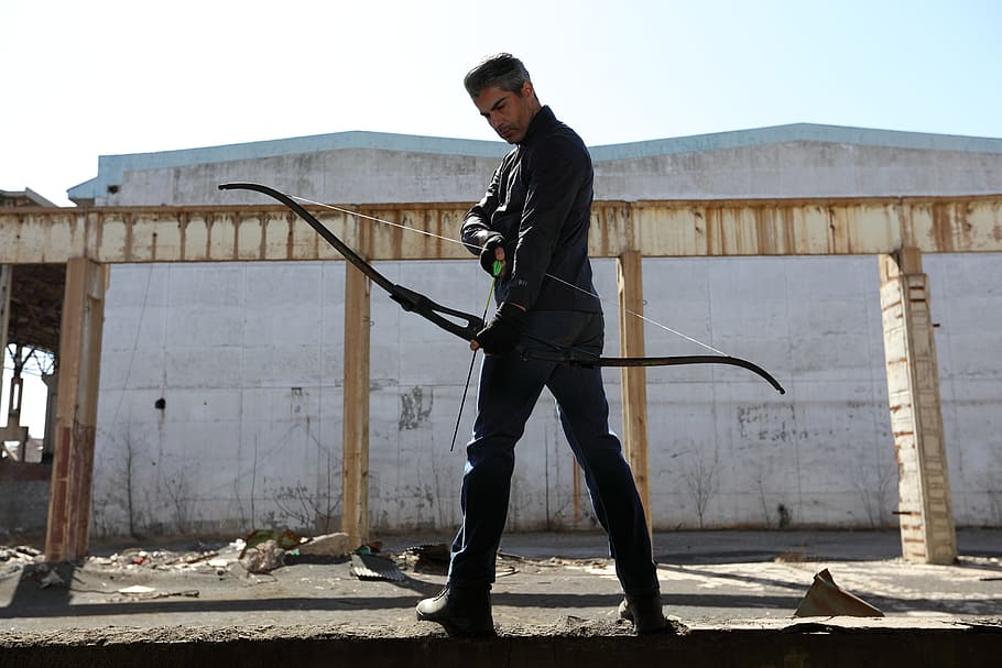 man holding black bow, warrior, dark, bow and arrow, one person HD wallpaper