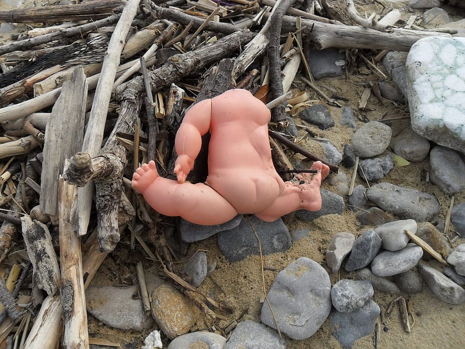 baby doll on driftwood and pebbles, kidnapping, beach, headless HD wallpaper