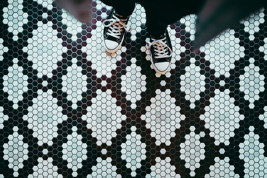 person standing wearing black sneakers, person standing on white and black tiled floor photo HD wallpaper
