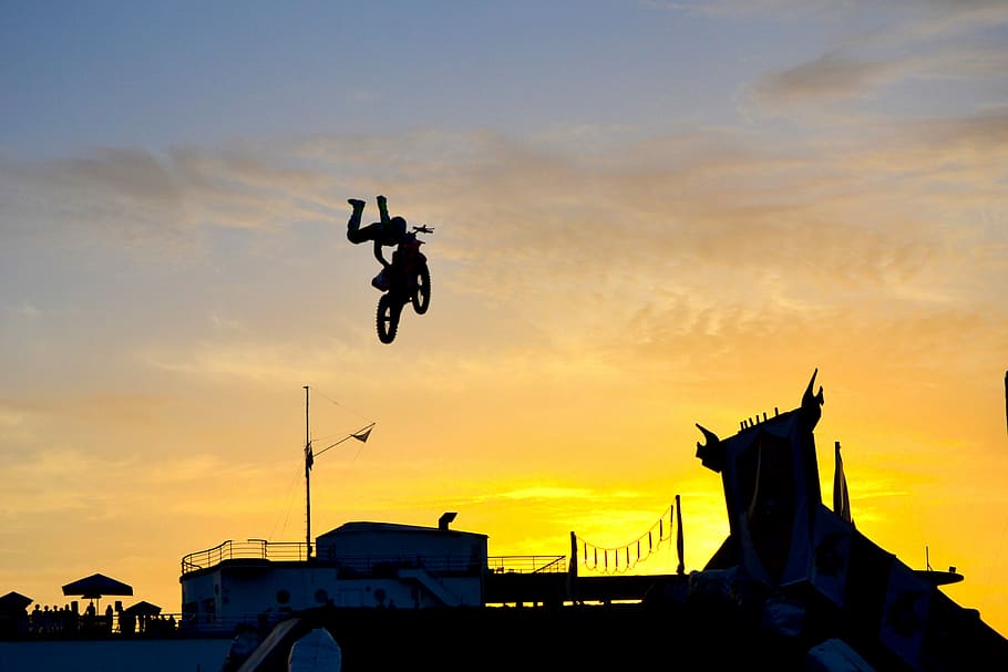 silhouette of person riding motocross dirt bike, silhouette photography of man doing tricks on dirt bike, HD wallpaper