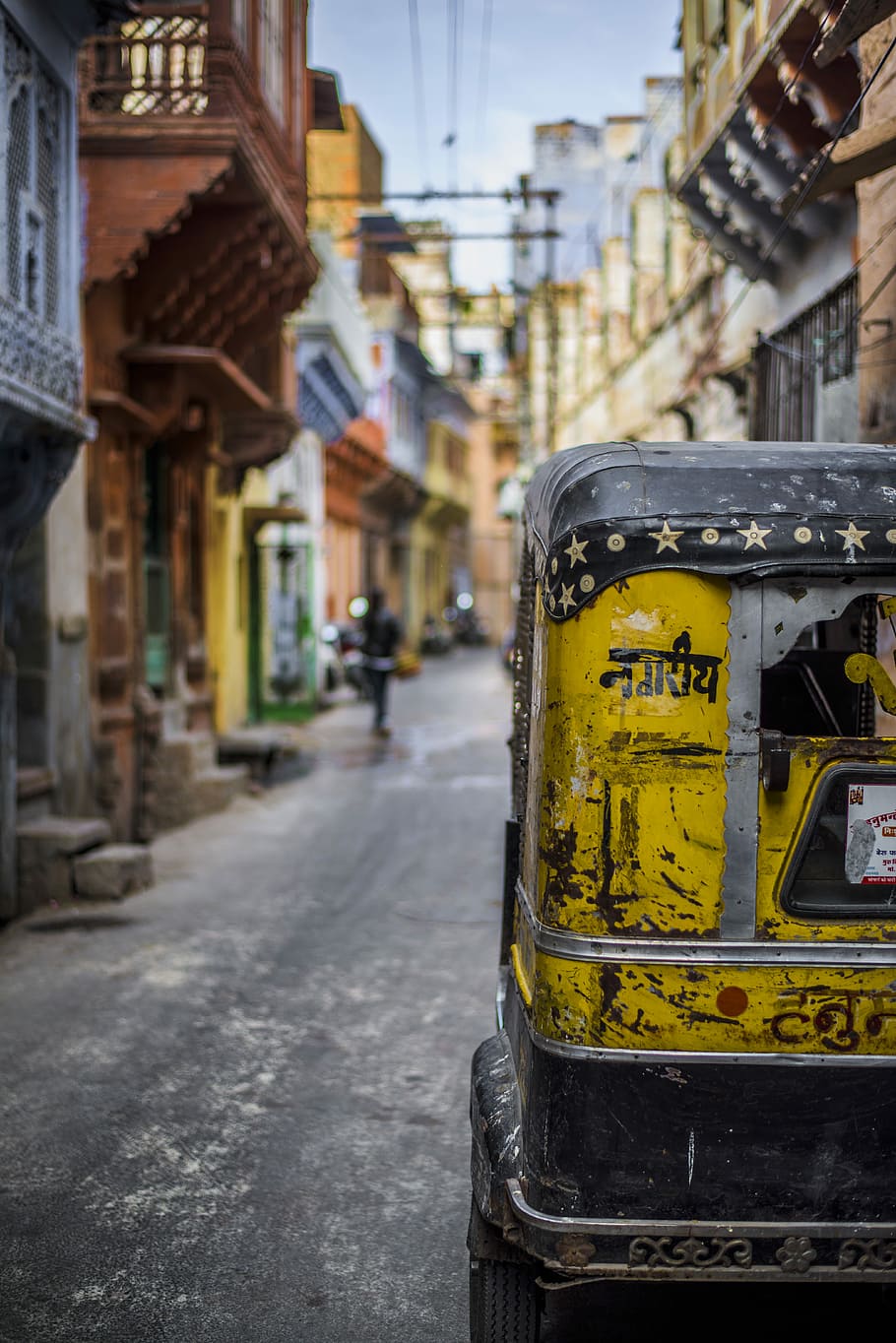 selective focus photography of yellow auto rickshaw on road, shallow focus photo of auto rickshaw