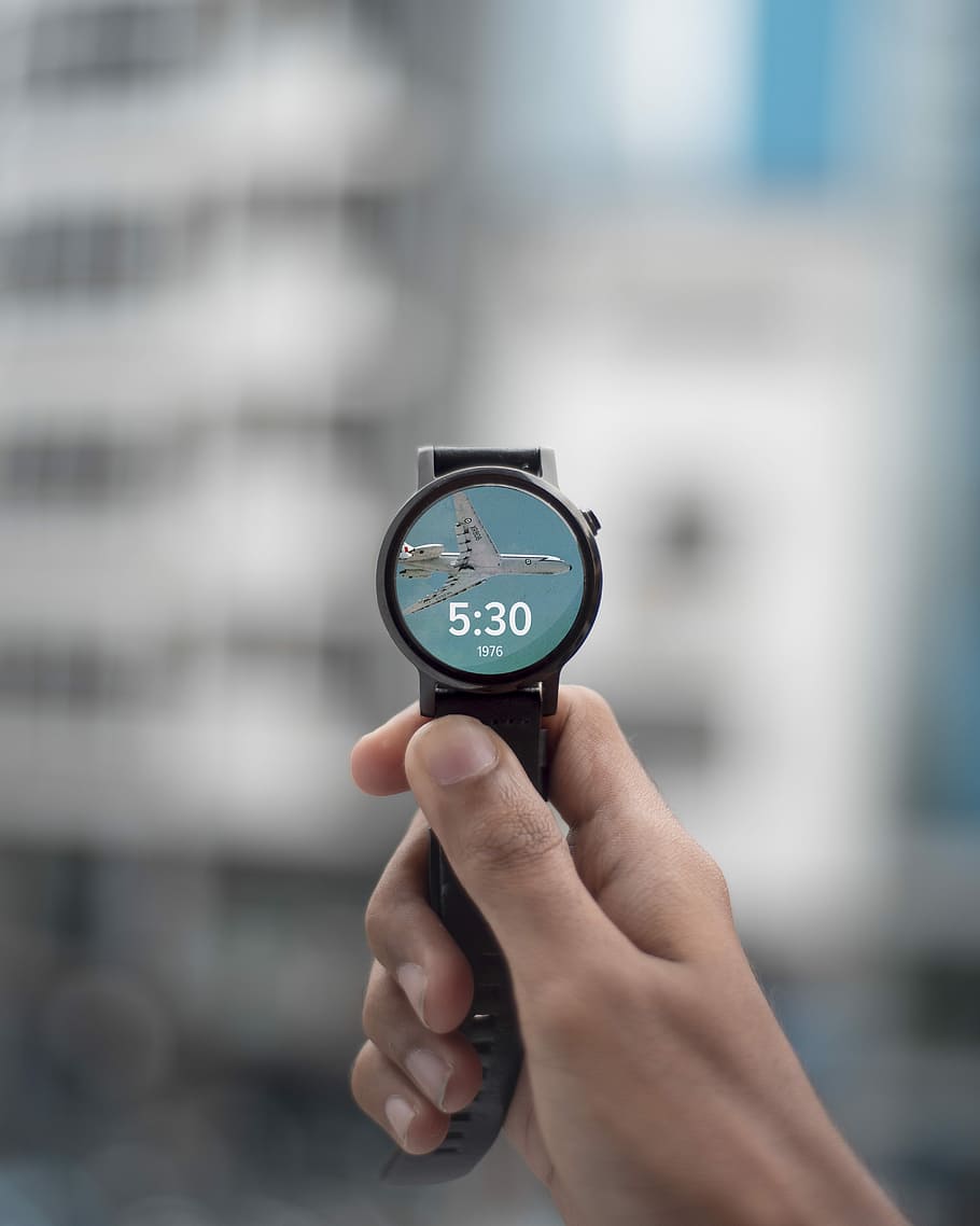 selective focus photography of person holding black smartwatch displaying 5:30, person holding round black analog watch HD wallpaper