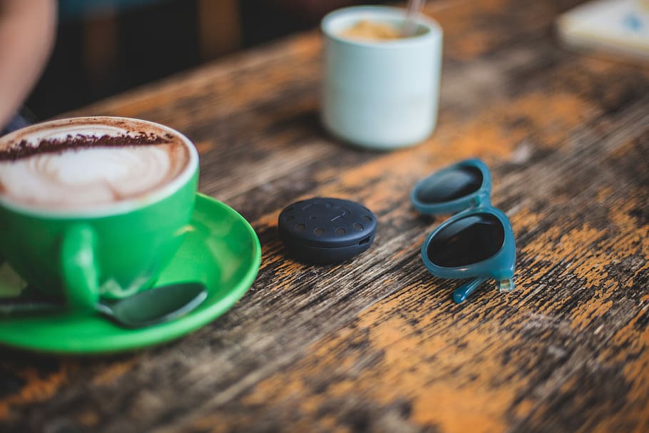 ceramic mug on saucer beside sunglasses, cappuccino in green cup HD wallpaper