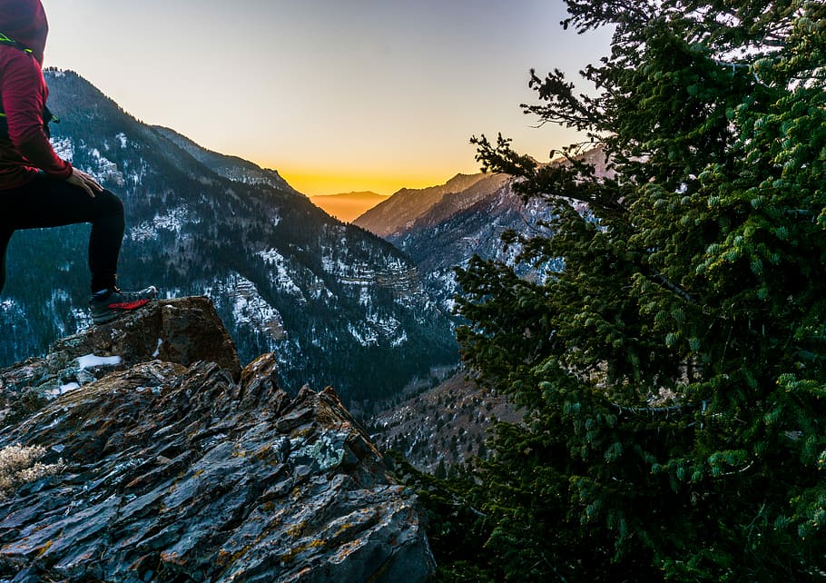 man on rock in front of mountain view, woman standing on cliff during daytime HD wallpaper