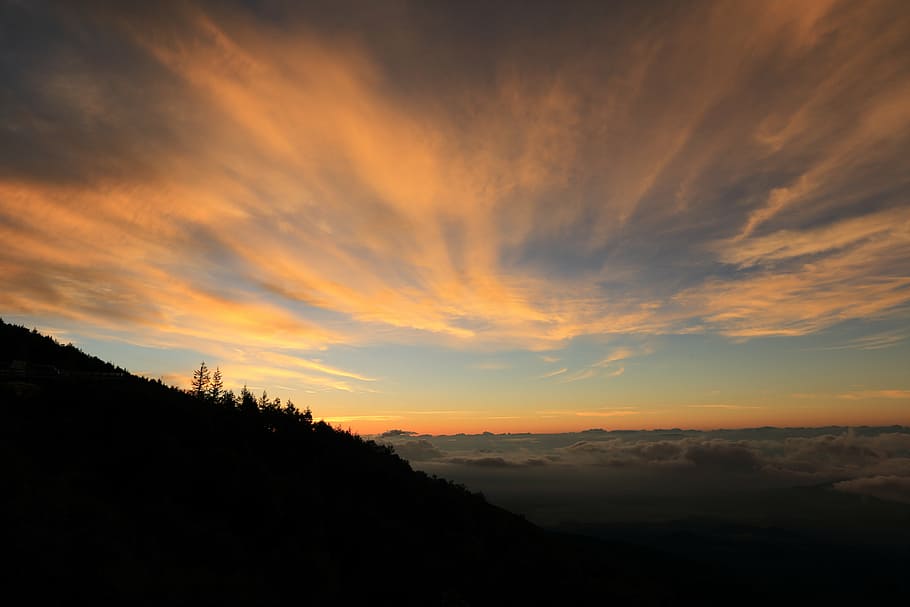 silhouette of mountain under orange and blue sky at sunset HD wallpaper