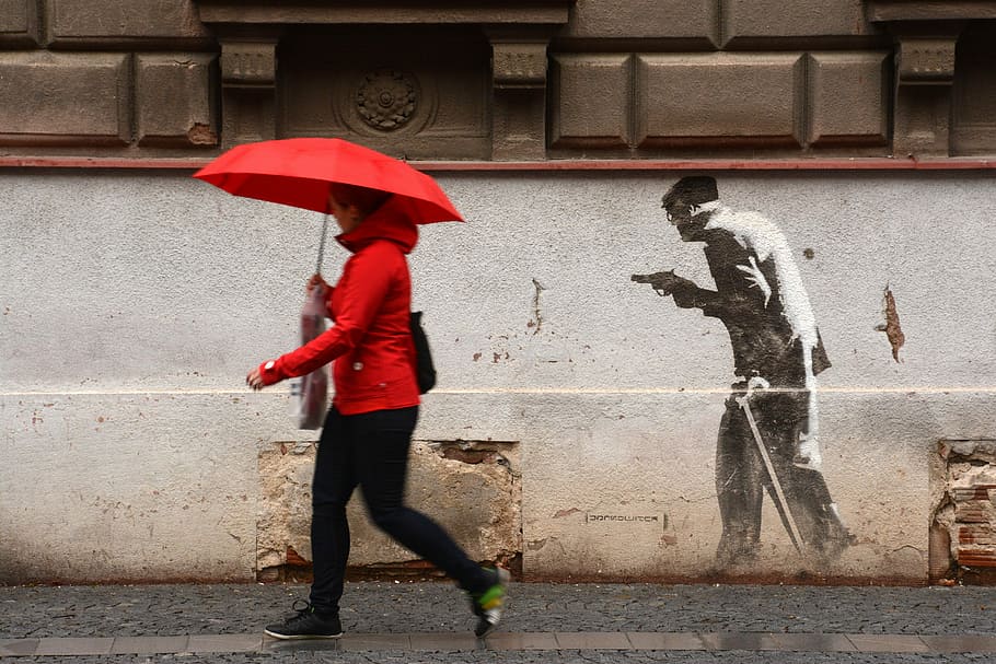 woman walking near wall while holding umbrella, Hradec Králové