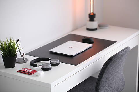 gray laptop on desk beside headphones, MacBook beside on-ear wireless headphones on wooden desk HD wallpaper