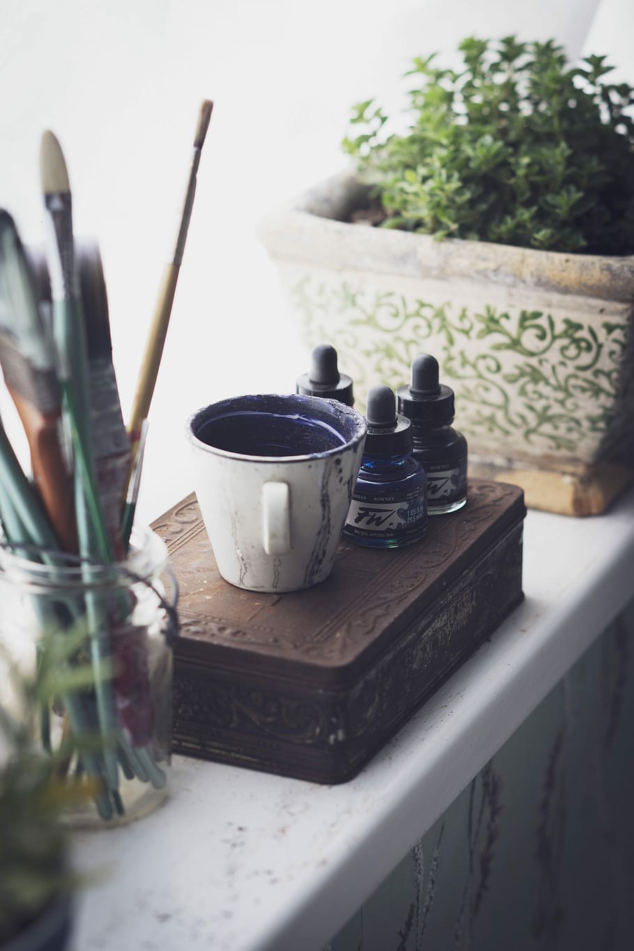 cup and ink bottles on top of chest box, white ceramic mug on top of case HD wallpaper