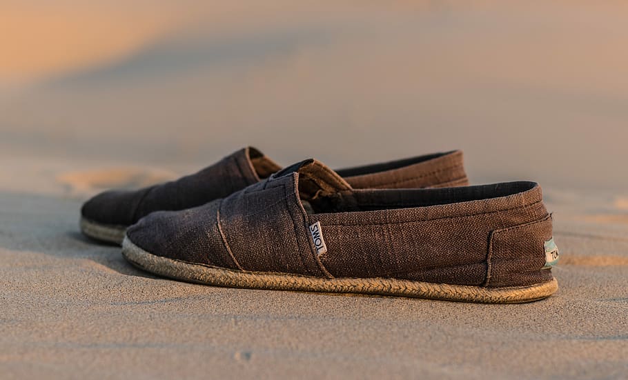 pair of brown Toms loafers on brown sand, pair of gray Toms shoes, HD wallpaper