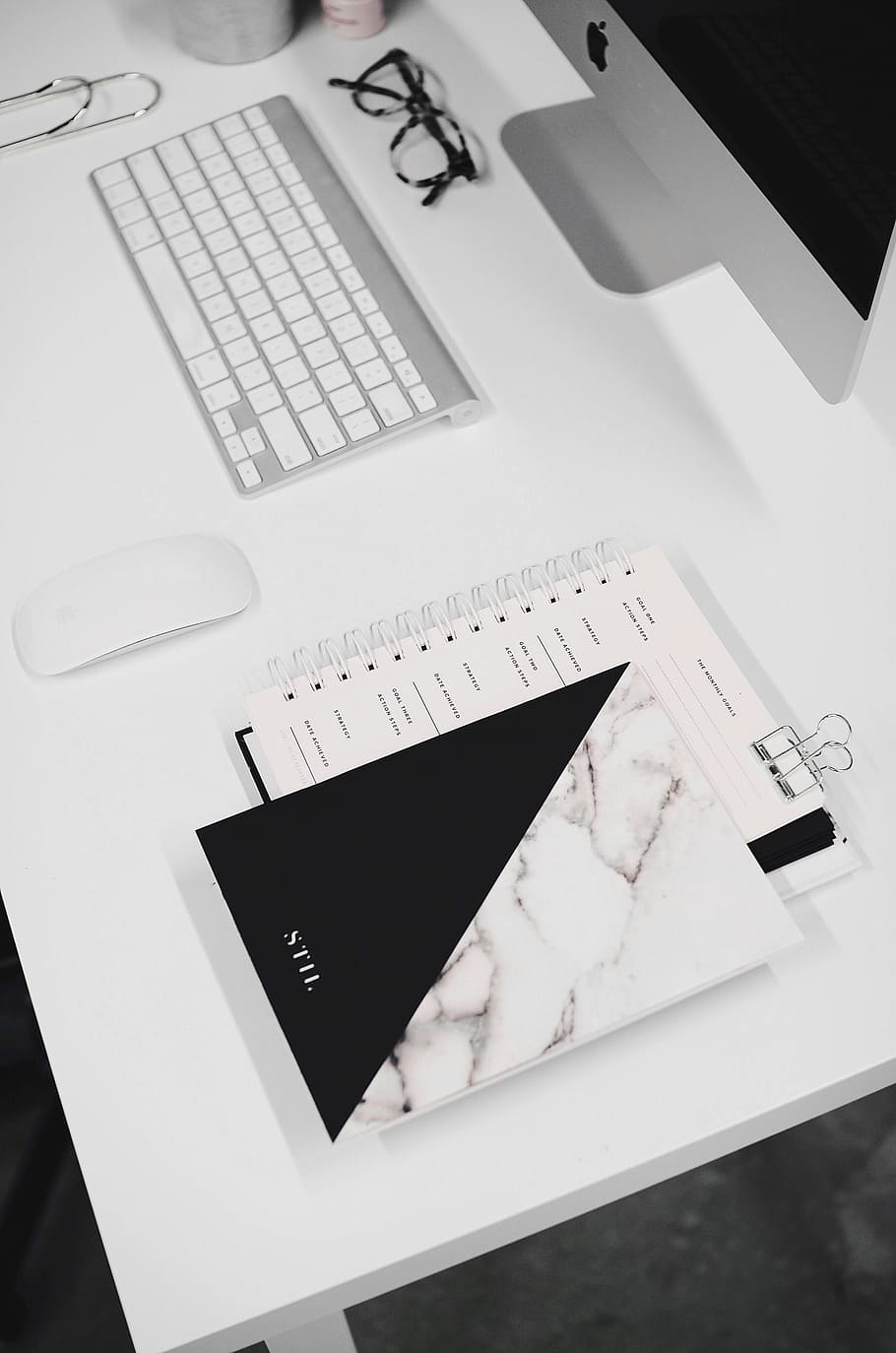 white and black notebook, white and black book beside white Apple magic mouse on white wooden desk HD wallpaper