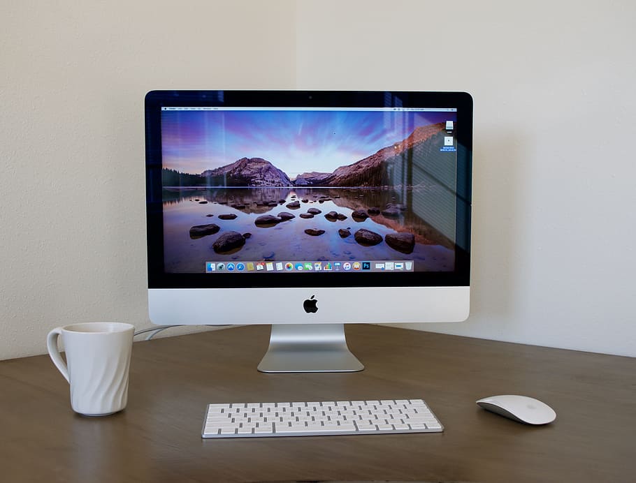 silver iMac, magic keyboard, and magic mouse on top of brown wooden table HD wallpaper